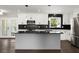 Modern kitchen featuring white cabinets, stainless steel appliances, black backsplash, and a center island at 3376 Irish Ln, Decatur, GA 30032