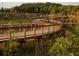 Curving boardwalk winds through a green landscape, providing a scenic walking experience amidst nature at 653 Summit Hill Way, Cumming, GA 30040