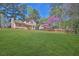 Backyard view with large, grassy area and exterior of the house at 1045 Forest Path, Stone Mountain, GA 30088