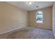 A simple bedroom featuring neutral walls, carpet and a bright arched window at 1045 Forest Path, Stone Mountain, GA 30088