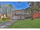 Traditional two-story home with an attached garage, lush green lawn, and mature trees in a serene setting at 1045 Forest Path, Stone Mountain, GA 30088