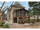 Back exterior showcasing a screened porch elevated on stone columns with convenient access stairs at 1109 Pine Grove Ne Ave, Brookhaven, GA 30319