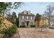 A traditional gray brick home boasts dormer windows, a covered porch, and neatly manicured landscaping at 1109 Pine Grove Ne Ave, Brookhaven, GA 30319