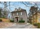View of gray brick home with mature landscaping, a quaint front porch, and shuttered windows at 1109 Pine Grove Ne Ave, Brookhaven, GA 30319