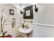 Charming powder room featuring a pedestal sink, decorative mirror, and wainscoting at 1109 Pine Grove Ne Ave, Brookhaven, GA 30319
