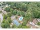Aerial view of community amenities including a pool, tennis court, lake, and surrounding homes at 1258 Rocky Branch Trl, Lawrenceville, GA 30043
