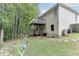 Backyard view featuring a home with a wooden deck, mature trees, and a garden at 1258 Rocky Branch Trl, Lawrenceville, GA 30043