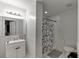 This simple, modern bathroom features neutral colors and a shower with a patterned shower curtain at 1258 Rocky Branch Trl, Lawrenceville, GA 30043