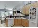Cozy kitchen with white appliances, wood cabinets and brick accents, open to dining area at 1258 Rocky Branch Trl, Lawrenceville, GA 30043