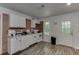 This simple kitchen features white cabinets, brick accents, and modern appliances at 1258 Rocky Branch Trl, Lawrenceville, GA 30043