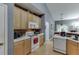 Functional kitchen with bright wood cabinets, white appliances, and brick accents at 1258 Rocky Branch Trl, Lawrenceville, GA 30043
