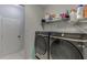 Bright laundry room features modern washer and dryer with storage shelving above at 1258 Rocky Branch Trl, Lawrenceville, GA 30043