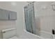 Bathroom with white tile, fixtures, shower/tub combo with neutral color curtain, and wall-mounted towel rack at 1384 Sheffield Glen Ne Way, Atlanta, GA 30329