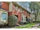 Charming red brick townhome featuring a bay window and well-manicured front yard at 1384 Sheffield Glen Ne Way, Atlanta, GA 30329