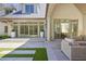 Elegant home exterior with expansive windows opening to a patio and well-maintained lawn at 3364 Knollwood Nw Dr, Atlanta, GA 30305