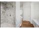 Marble bathroom with a walk-in shower, white walls, and hardwood floors at 3364 Knollwood Nw Dr, Atlanta, GA 30305