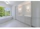 Beautiful bathroom featuring a soaking tub, white cabinetry, and custom lighting fixtures at 3364 Knollwood Nw Dr, Atlanta, GA 30305