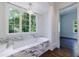 Bright bathroom with a large window, a soaking tub and marble surround at 3364 Knollwood Nw Dr, Atlanta, GA 30305