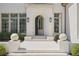 Elegant entrance with an arched doorway and white stone steps, with decorative greenery at 3364 Knollwood Nw Dr, Atlanta, GA 30305