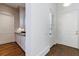 Bright hallway featuring hardwood floors, white trim, and a doorway to a kitchen area at 3364 Knollwood Nw Dr, Atlanta, GA 30305