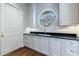 Well-lit mudroom with custom cabinets, black countertops, a round window and hardwood floors at 3364 Knollwood Nw Dr, Atlanta, GA 30305