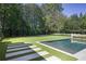 Backyard pool with integrated spa, lush landscaping, creating a private oasis for relaxation at 3364 Knollwood Nw Dr, Atlanta, GA 30305