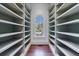 Bright walk-in closet boasts extensive shelving and a beautiful arched window providing ample natural light at 3364 Knollwood Nw Dr, Atlanta, GA 30305
