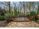 Backyard featuring a wooden deck, stone pavers, and mature landscaping at 1603 Pinder Point Dr, Lawrenceville, GA 30043
