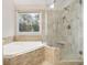Updated bathroom with glass-enclosed shower, soaking tub, and natural light at 1603 Pinder Point Dr, Lawrenceville, GA 30043