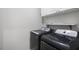 Laundry area featuring front loading washer and dryer and white cabinets above at 1603 Pinder Point Dr, Lawrenceville, GA 30043