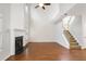 Open living room with fireplace, hardwood floors, and staircase access at 1603 Pinder Point Dr, Lawrenceville, GA 30043