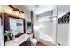Bright bathroom featuring a wooden-framed mirror above the vanity and a bathtub with tile surround at 7492 Shadburn Ferry Rd, Cumming, GA 30041