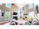 Bright and airy living room featuring high ceilings, a fireplace, and large windows at 7492 Shadburn Ferry Rd, Cumming, GA 30041