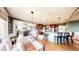Open-concept kitchen and dining area with hardwood floors, modern lighting, and a view into the living room at 7492 Shadburn Ferry Rd, Cumming, GA 30041