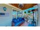 Cozy covered patio with a blue couch, ceiling fan, and view of the backyard at 7492 Shadburn Ferry Rd, Cumming, GA 30041