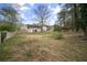 Large backyard with lush green grass, mature trees, and a wooden fence surrounding the property at 1517 Cherry Hill Sw Rd, Conyers, GA 30094