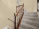 Carpeted staircase with wood banister and neutral colored walls at 1517 Cherry Hill Sw Rd, Conyers, GA 30094