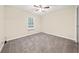Bedroom features neutral paint, plush carpeting, and natural light from the window at 235 Shallowford Nw Rd, Kennesaw, GA 30144