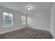 Bright bedroom with carpet, two windows with blinds, and freshly painted walls at 3945 Hamilton Cove Ct, Cumming, GA 30028