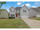 Charming two-story home featuring gray siding, a red front door, and a well-maintained lawn at 3945 Hamilton Cove Ct, Cumming, GA 30028