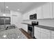 Bright kitchen featuring white cabinets, granite countertops, and stainless steel appliances at 3945 Hamilton Cove Ct, Cumming, GA 30028