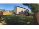 Large fenced backyard with lawn, features play set, mature trees and a view of the home's back exterior at 1606 Kenilworth Se Ln, Conyers, GA 30013