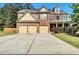 Charming two-story home with a brick facade, a manicured lawn, and a spacious three-car driveway at 1606 Kenilworth Se Ln, Conyers, GA 30013