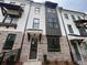 New townhome exterior featuring a brick and white facade with black window trim and modern architectural details at 627 Silva St # 127, Cumming, GA 30040