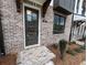 Brick walkway leading to the front door of a townhome, landscaped with new mulch and greenery at 627 Silva St # 127, Cumming, GA 30040