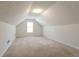 Spacious attic with neutral carpet, angled ceilings, and a window for natural light at 1056 Fern Valley Way, Dacula, GA 30019