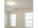 Bright bedroom featuring neutral walls, carpet flooring, and two windows that provide natural light at 1056 Fern Valley Way, Dacula, GA 30019
