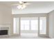 Bright living room featuring a fireplace, fan, and large windows, offering a welcoming atmosphere at 1056 Fern Valley Way, Dacula, GA 30019