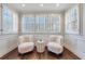 Bright sitting room with hardwood floors, two chairs and many windows at 1287 University Ne Dr, Atlanta, GA 30306