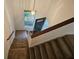 A carpeted staircase with wooden handrail next to a window and a dark-colored door in a bright, naturally lit entryway at 2209 N Forest Trl, Dunwoody, GA 30338